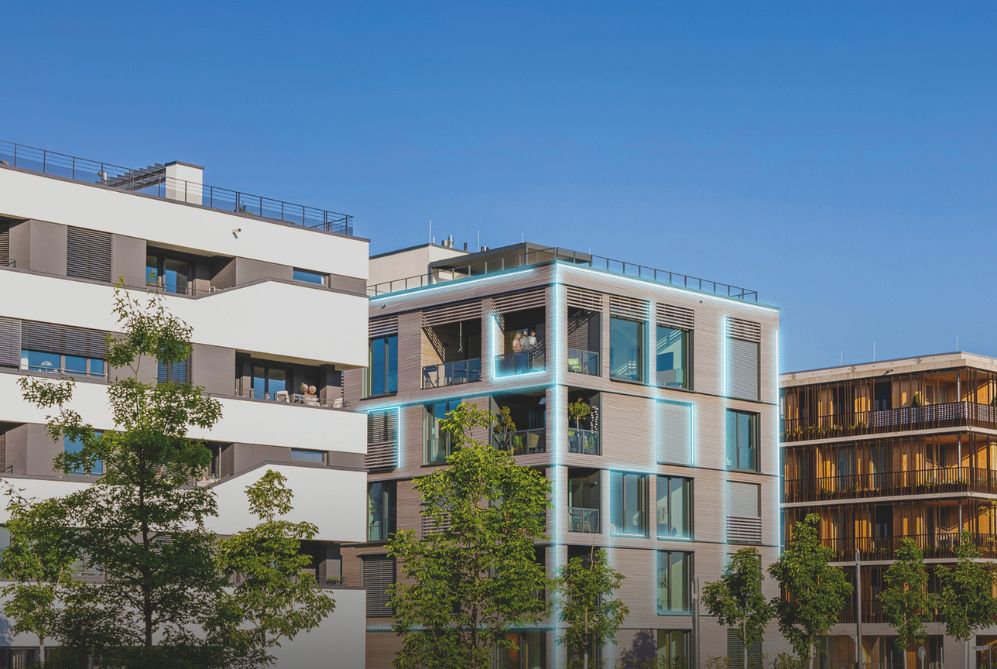 En bygning laget av murstein, som gir den et klassisk og solid utseende. Foran bygningen står det flere trær, som tilfører et naturlig element til omgivelsene og gir en følelse av ro.