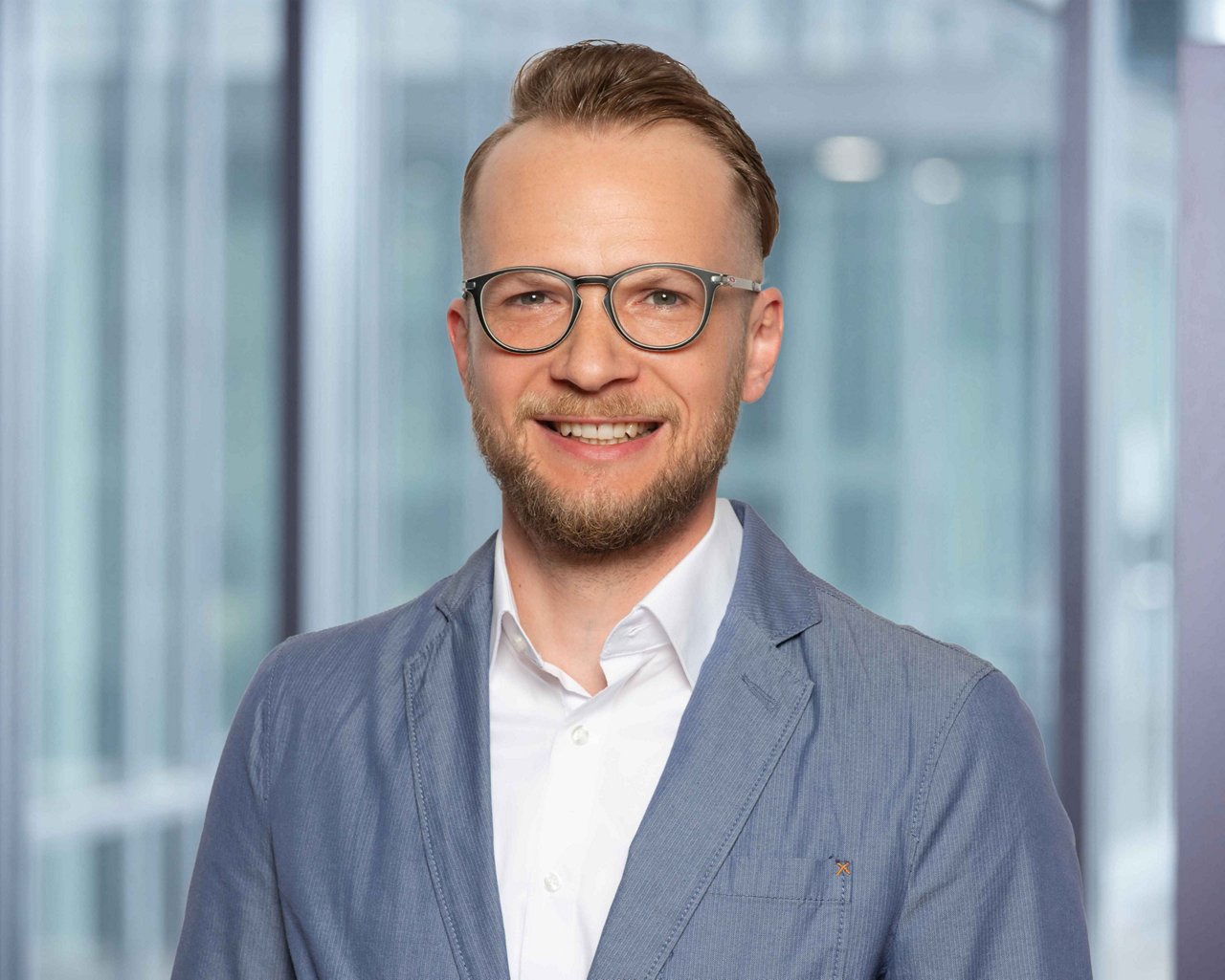 Photo du responsable des relevés et de la facturation S. Fenkl sur un fond de bureau flou.