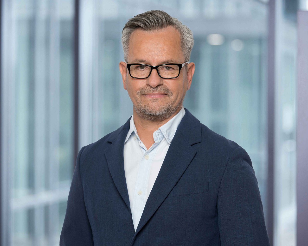 Foto Verkaufsberater C. Carrasco der Region Westschweiz vor unscharfem Bürohintergrund.