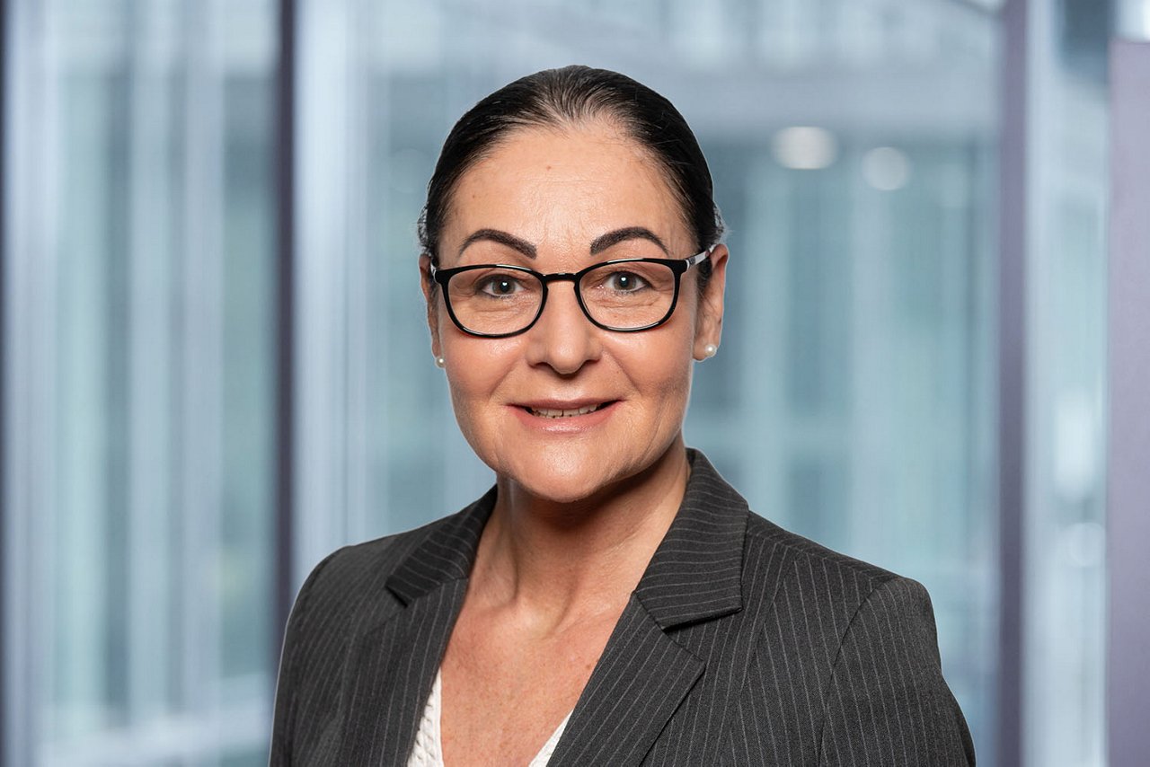 Photo de la directrice des ressources humaines C. Vegliante sur un fond de bureau flou.