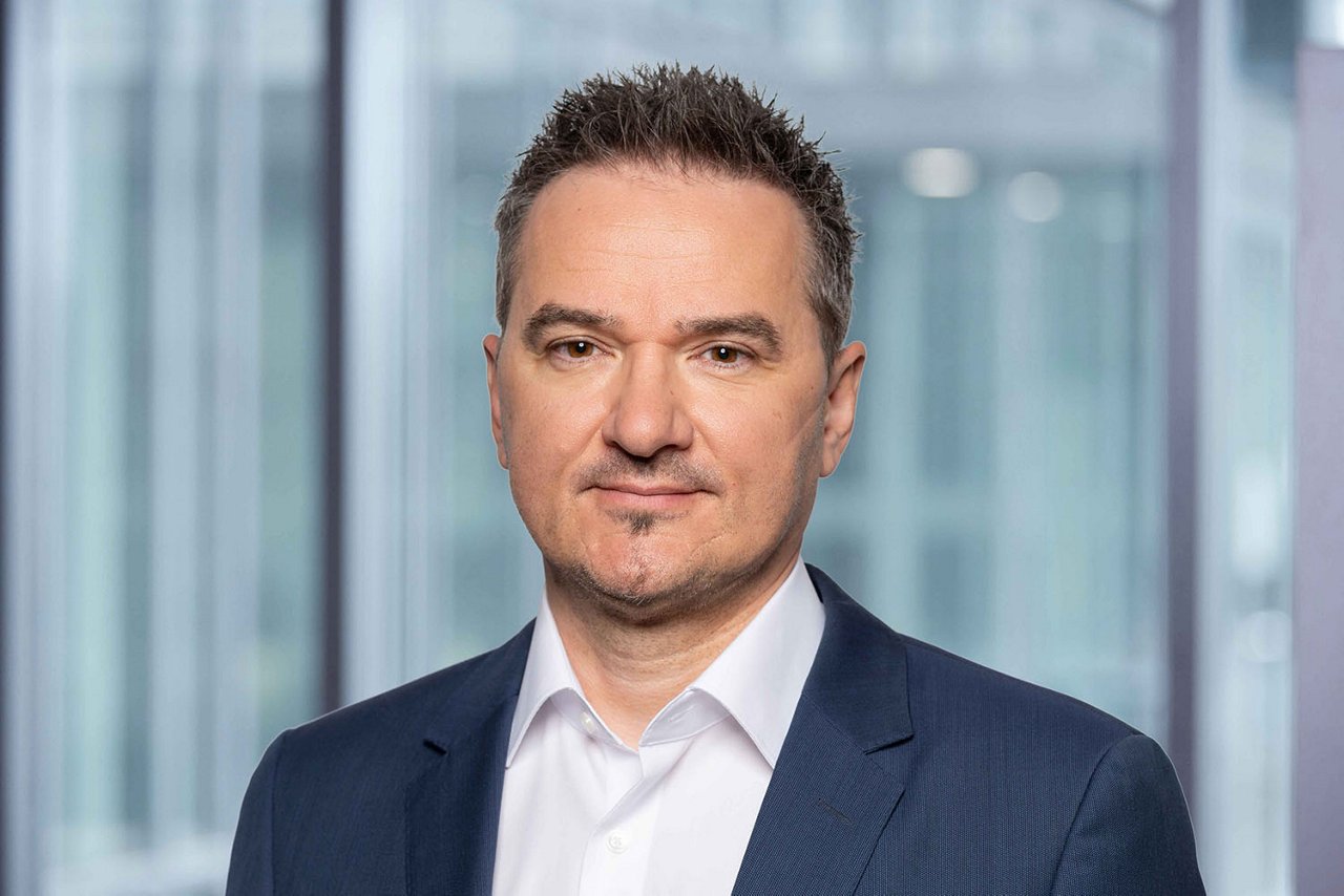 Photo conseiller de vente M. Heiniger région BE, SO et VS-fr devant un arrière-plan flou de bureau.