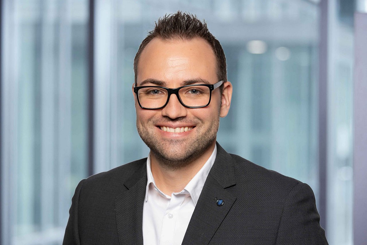 Photo conseiller de vente R. Ceccarelli région Zurich et Schaffhouse devant un arrière-plan de bureau flou.