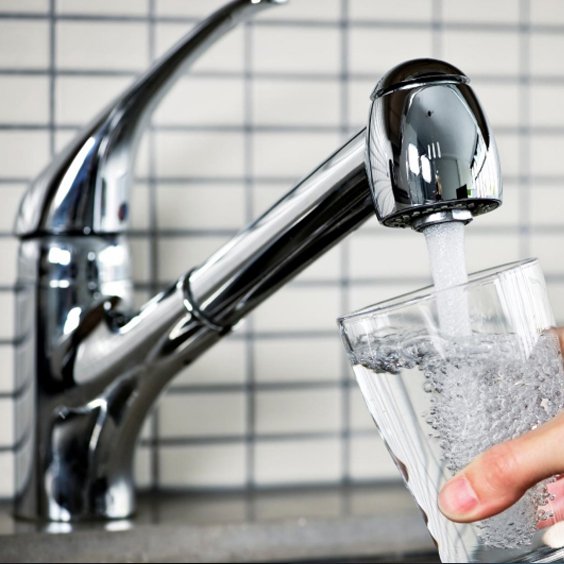 En vandhane fylder et glas 