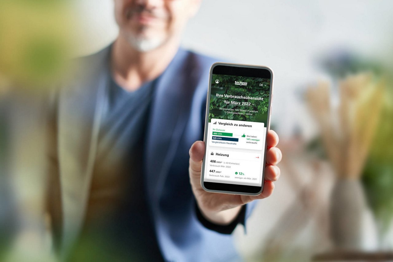 Mann zeigt Smartphone mit EED Verbrauchsinfo