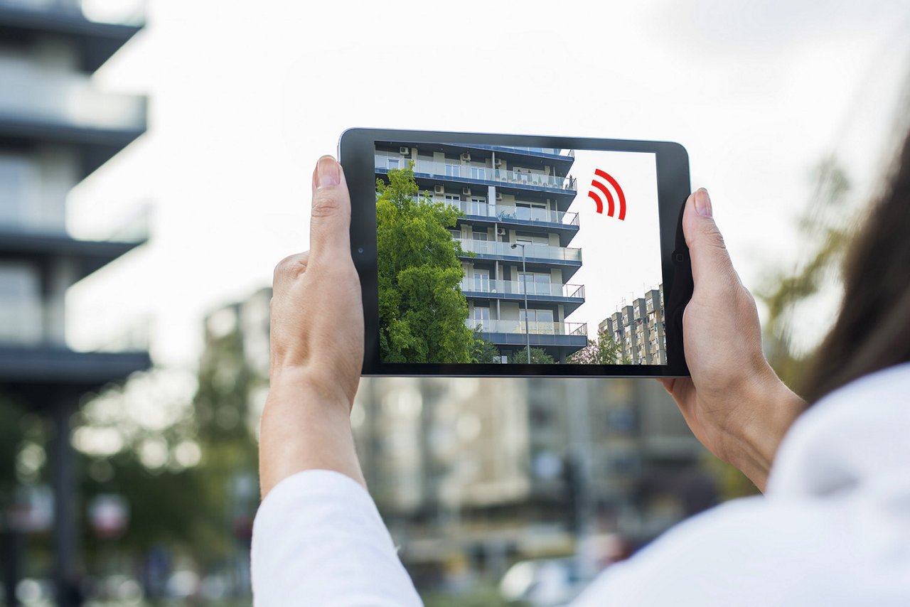 Kvinde står med tablet, der viser vores radiobølger. 
