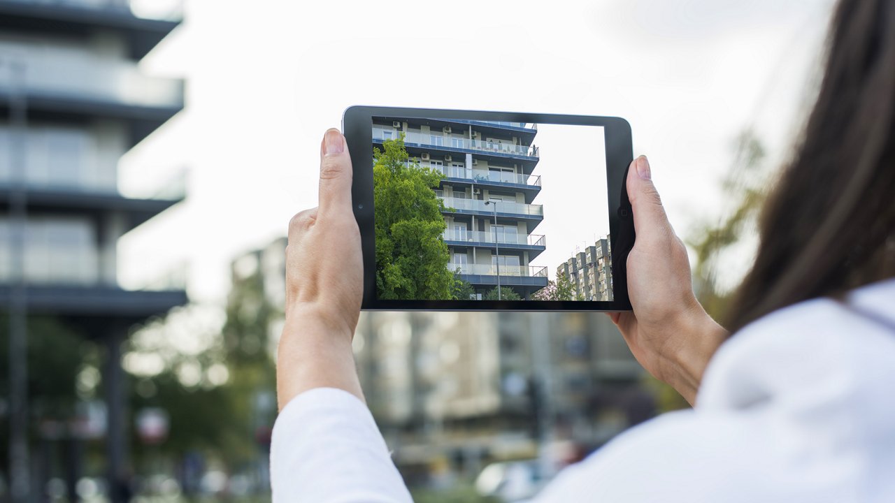 Frau fotografiert mit Tablet ein Gebäude