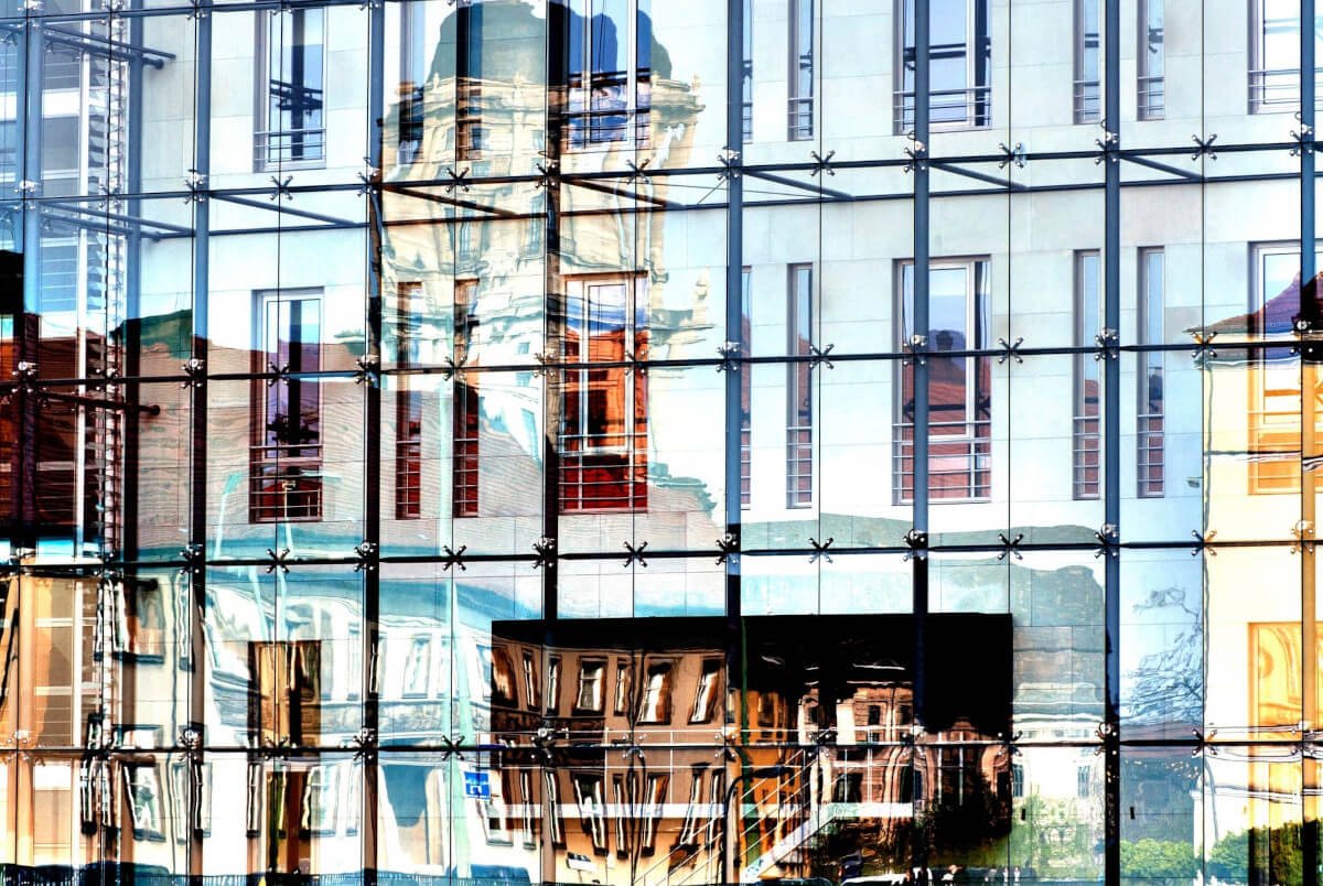 Der Kontrast zwischen alt und neu, sowie die geometrische Struktur der modernen Architektur und die organischen Formen des älteren Gebäudes, schaffen einen interessanten visuellen Effekt.