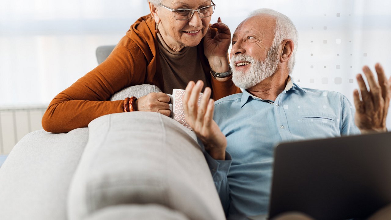 Älteres Paar auf dem Sofa mit Laptop