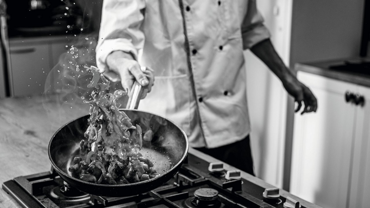 Koch schwenkt Pfanne