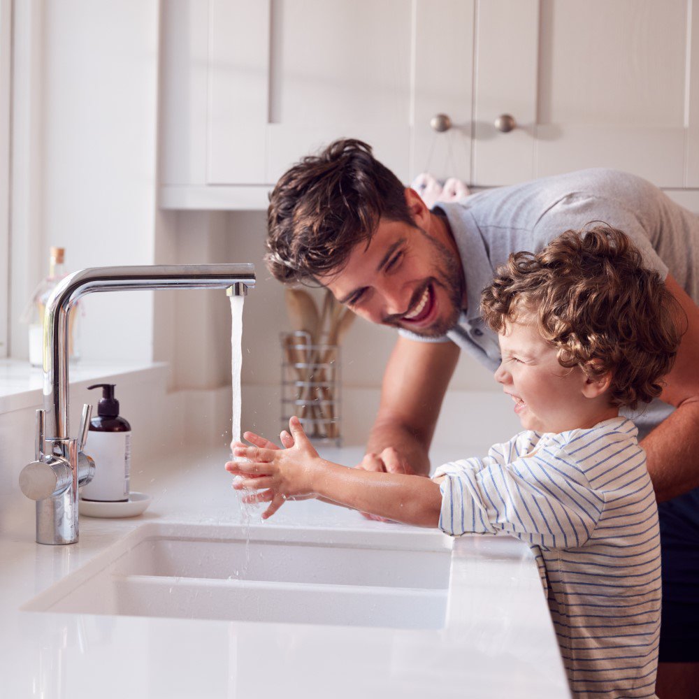 Mann mit Kind am Waschbecken - Techem Motiv für die Legionellenrprüfung