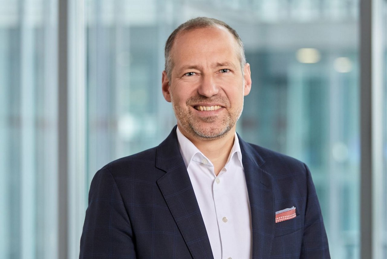 alt-Text: Profilbild von Matthias Hartmann vor Glaswand
