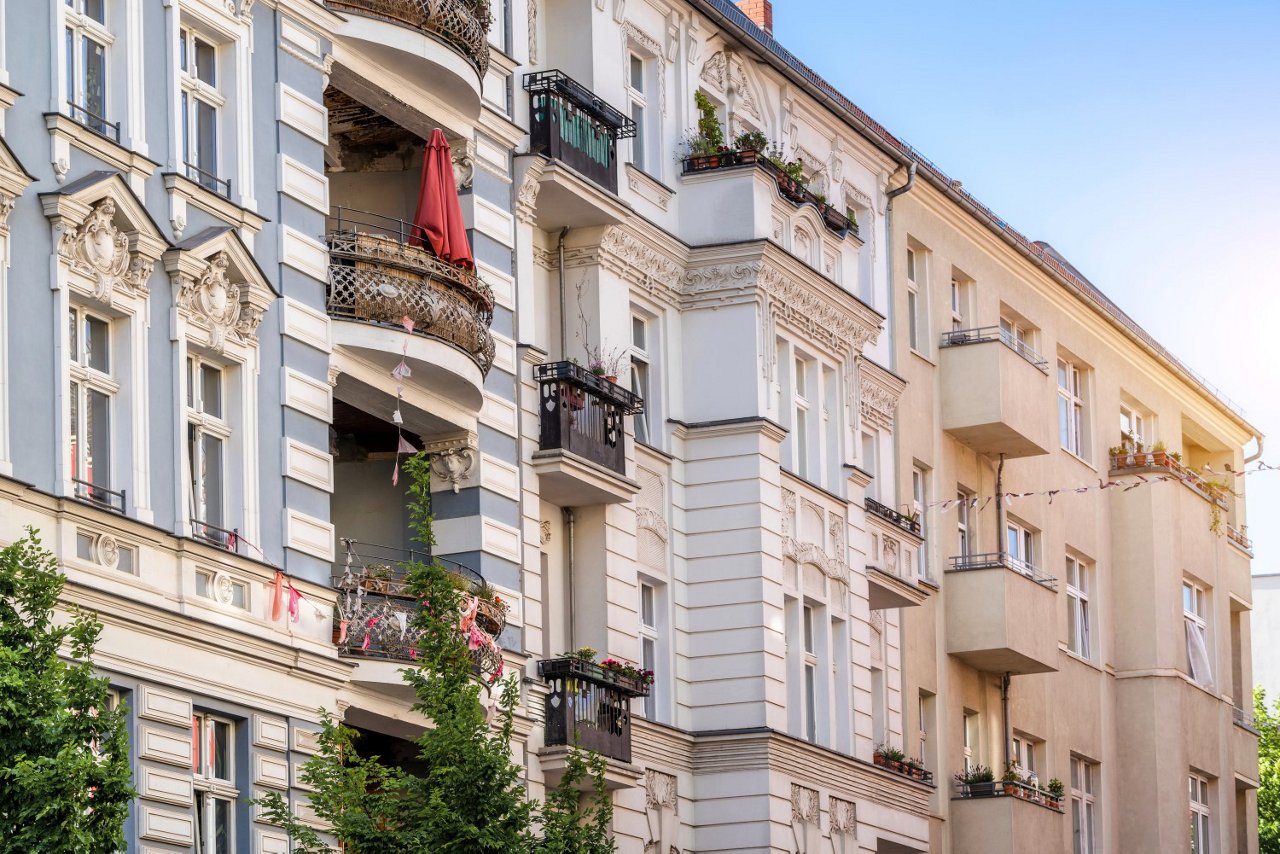 Fassade eines historischen Mehrfamilienhauses mit Balkonen und Blumenkästen in einer Stadt