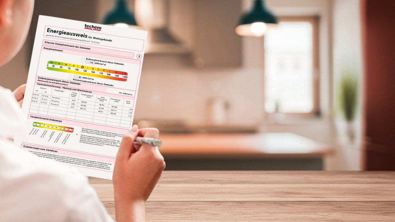 Mann sitzt am Küchentisch und hält ein Energieausweis in der Hand
