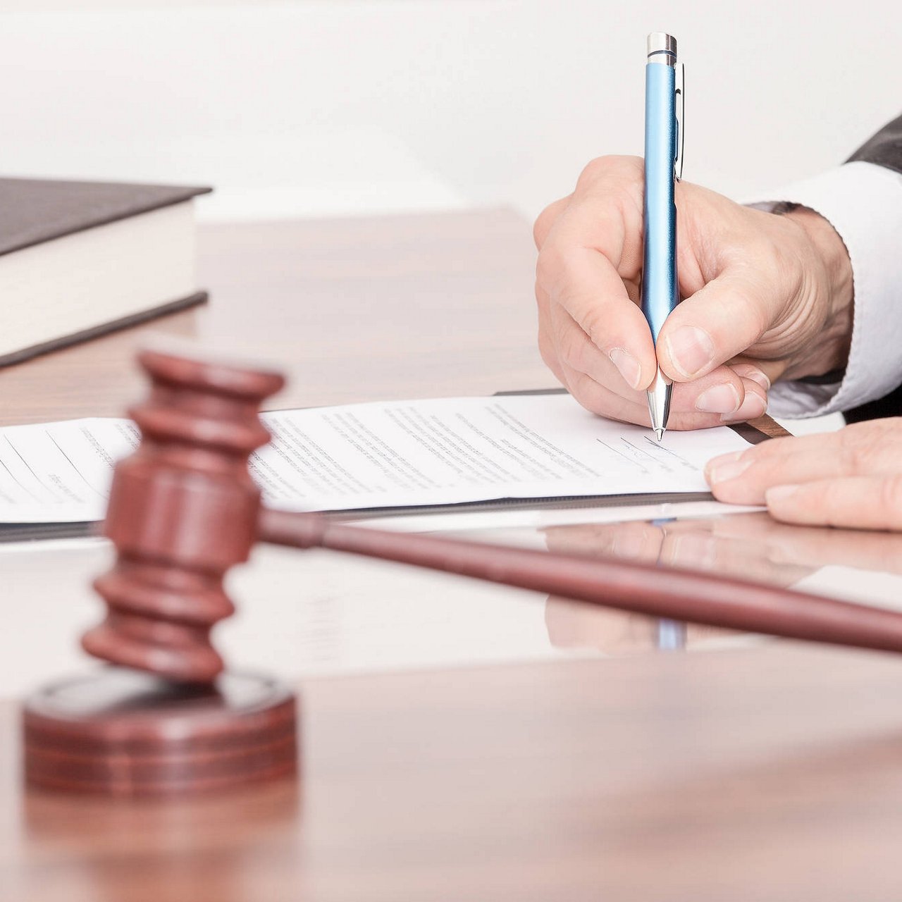 Mannlig dommer skriver på papir i rettssalen.