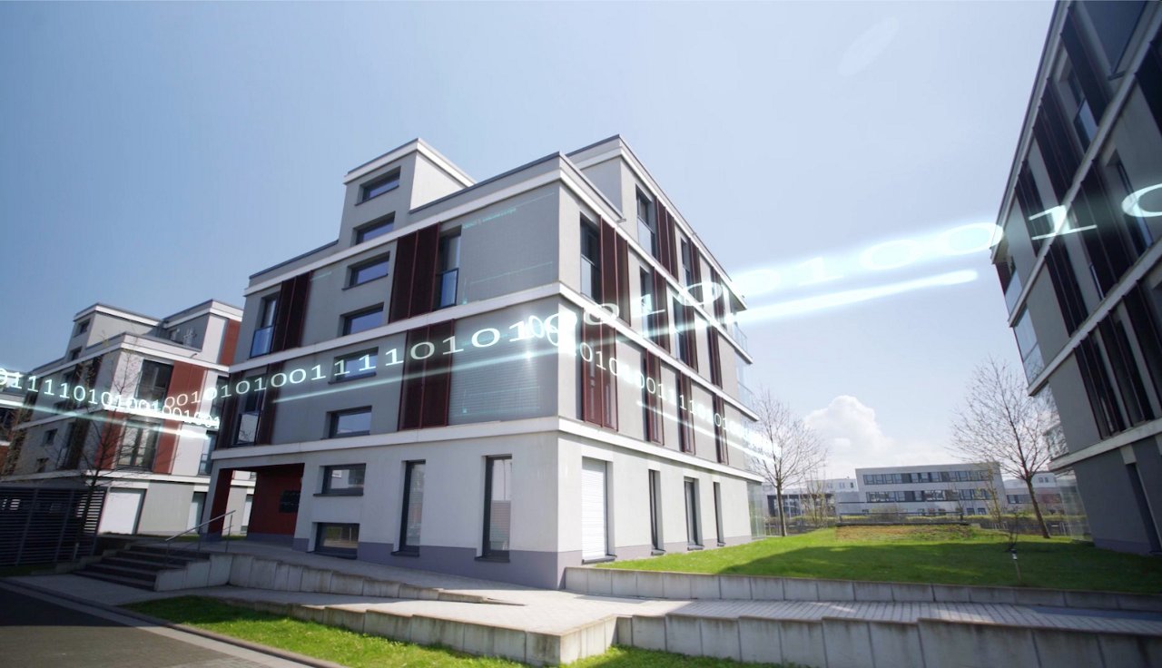 Ein modernes, mehrstöckiges Wohn- oder Bürogebäude mit weißen und grauen Fassadenelementen. Über die Fassade ist ein digitaler Datenstrom mit Nullen und Einsen visualisiert, der das Thema Smart Building oder digitale Gebäudetechnik symbolisiert.