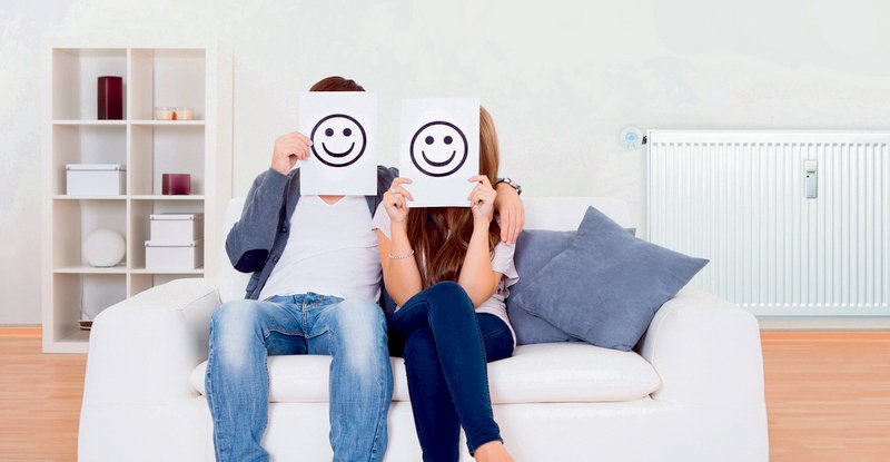 Couple covered faces with smiley white paper.; Shutterstock ID 120403153