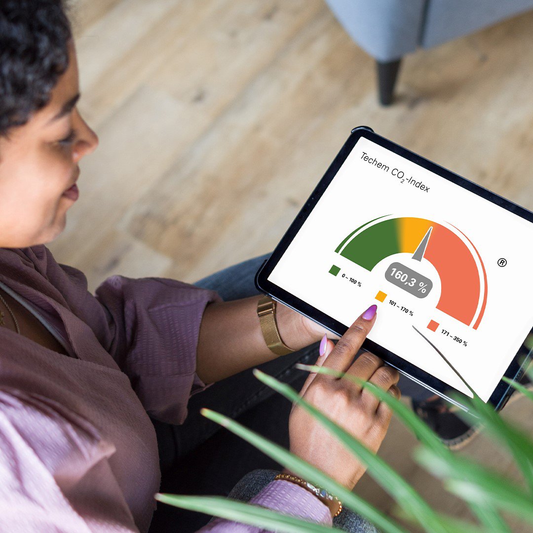 alt-Text: Frau lässt sich CO2-Index am Tablet anzeigen