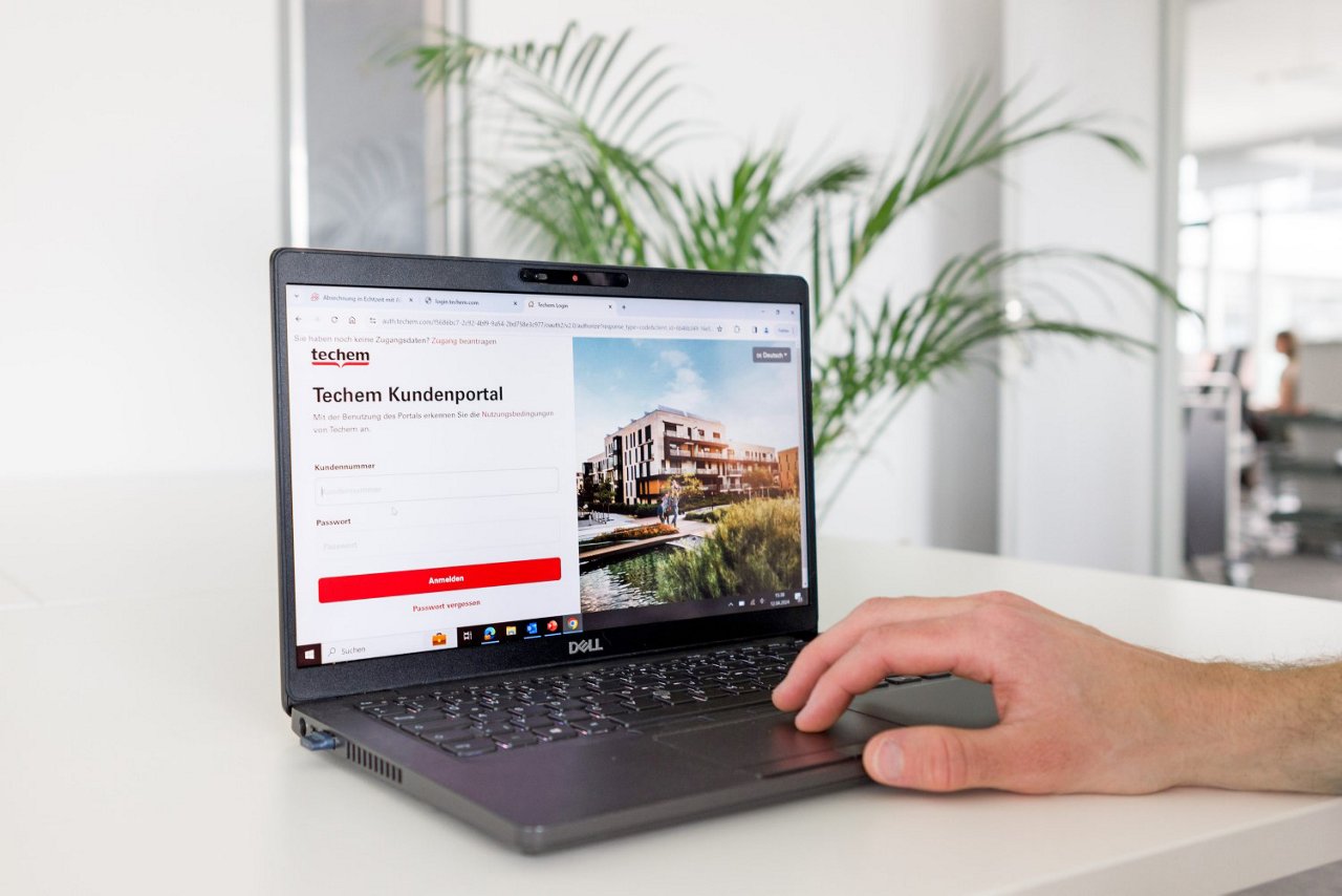 Ein geöffneter Laptop zeigt die Login-Seite des Techem Kundenportals.