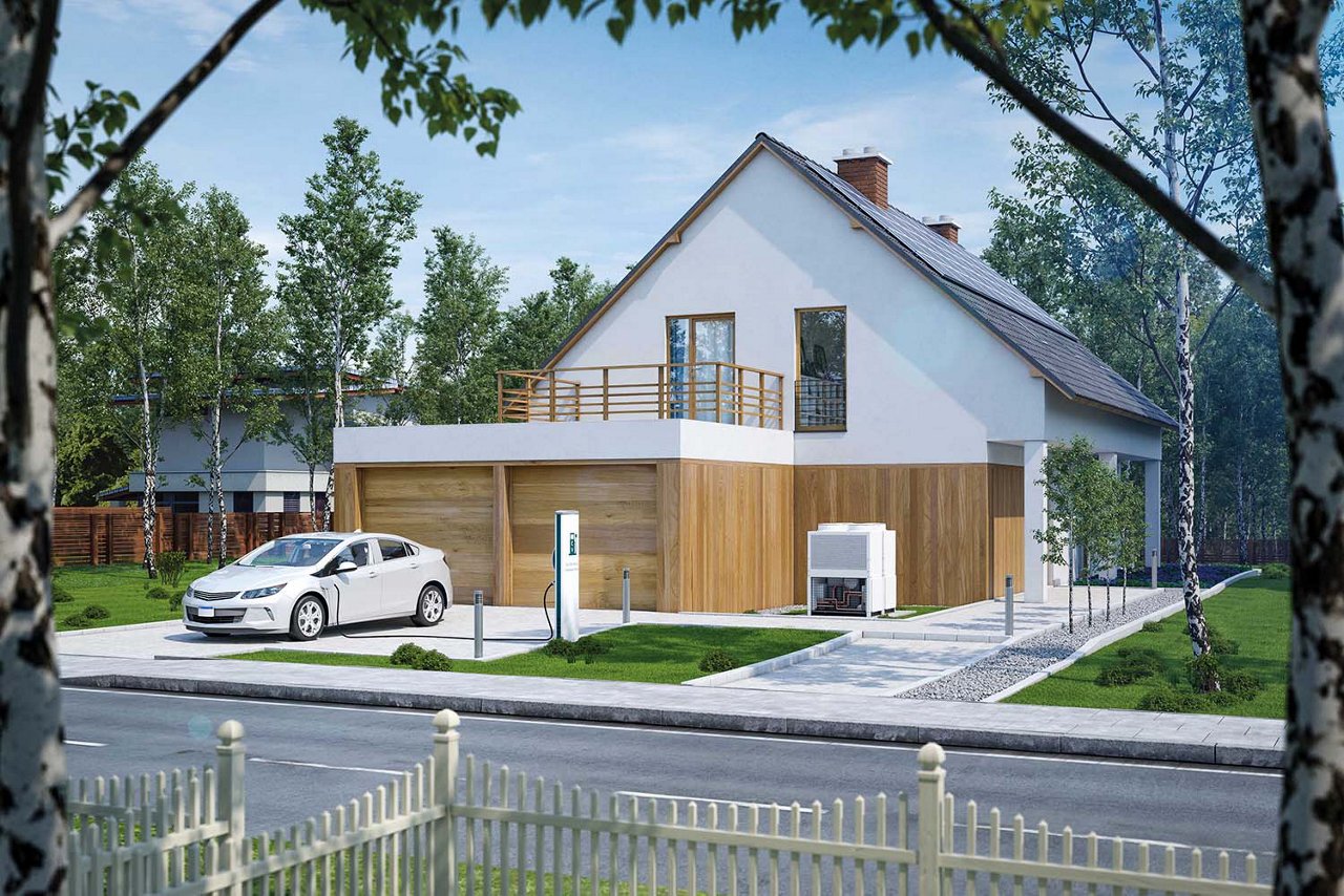 Zu sehen ist ein Einfamilienhaus mit Grünflächen. Davor steht ein Elektroauto, das gerade an einer Ladestation lädt.