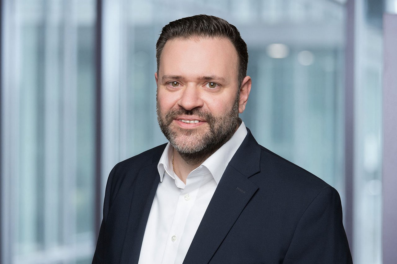 Photo de la directrice des ressources humaines C. Vegliante sur un fond de bureau flou.