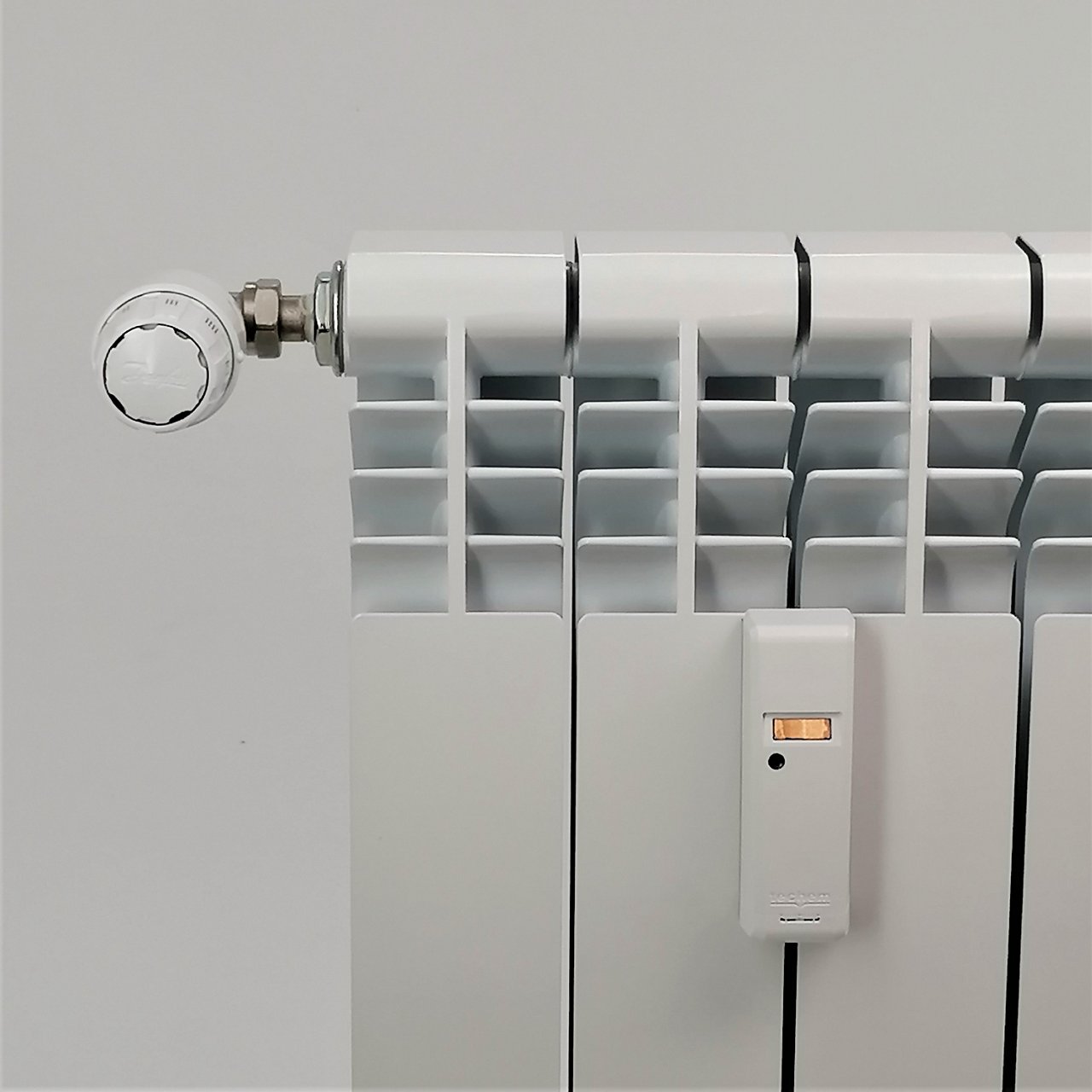 Radiador con un repartidor de costes de calefacción instalado entre dos de las barras verticales.